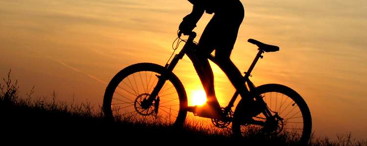 Велосипедист катается на закате
